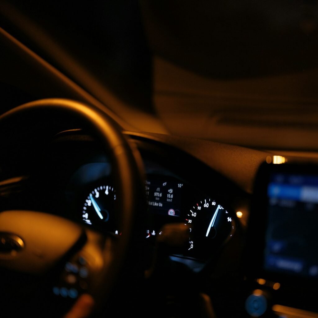 Car dashboard glowing at night with the gauges lit